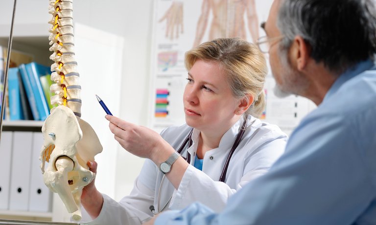  רופא המסביר למטופל סיבוכים אפשריים המתבטאים במחלת עצם מטבולית בשל CKD