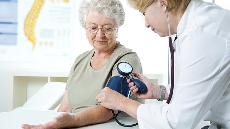 רופאה מודדת לחץ דם של אישה